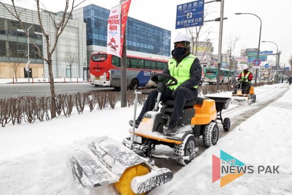 26일 시 관계자가 처인구 역북동 일원 인도에 쌓인 눈을 제설기로 치우고 있다.