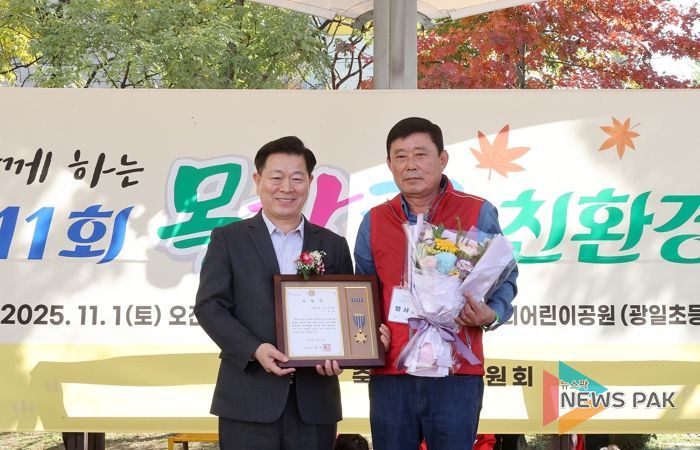 박승원 광명시장이 지난 1일 우리어린이공원에서 열린 ‘제11회 가족과 함께하는 목감천 친환경 축제’에 참석해 광명6동 주민자치회 위원에게 시장표창을 수여하고 기념사진을 촬영하고 있다.