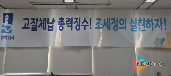 ‘고질체납 총력 징수! 조세정의 실현하자!’ 수원시 징수과 사무실에 걸려 있는 현수막.