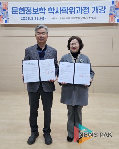 윤미영 도서관정책과장과 가천대 평생교육원 이재원 주임교수가 협약서를 들고 기념촬영을 하고 있다